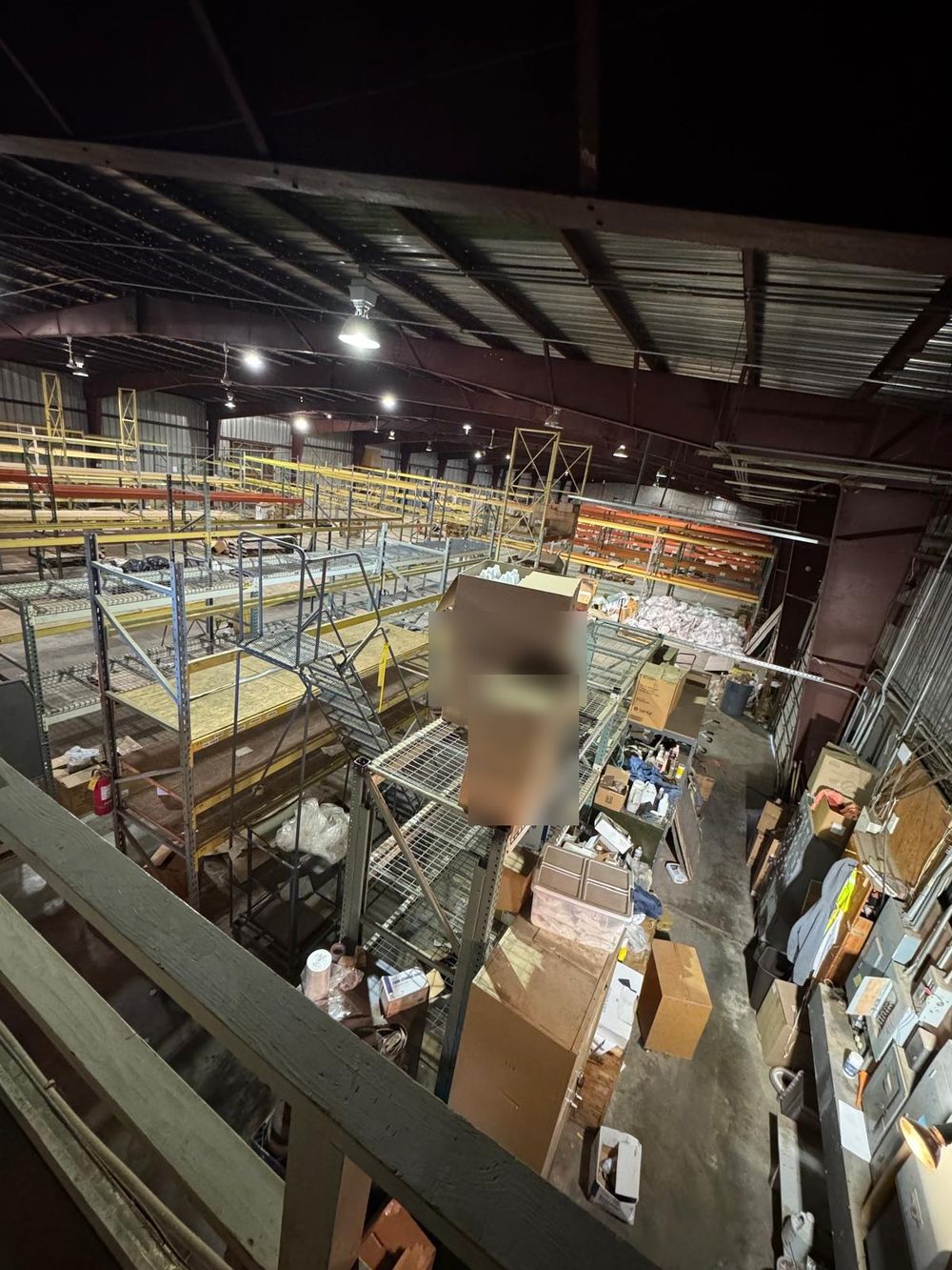 Before: racking, shelving and boxes crowding the floor below the mezzanine