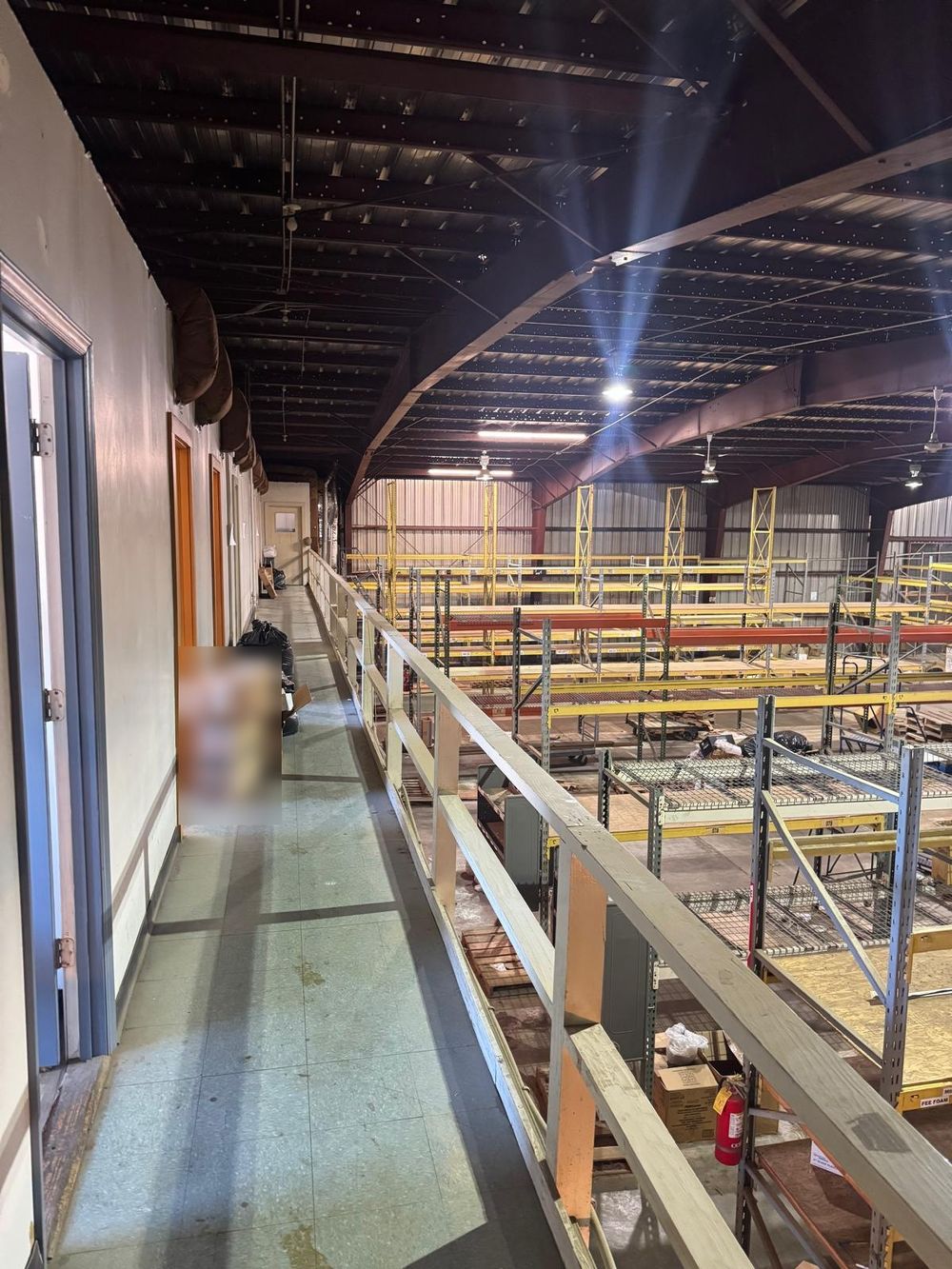 Before: the mezzanine walkway overlooking rows of yellow pallet racking
